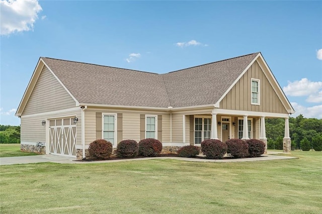 view of front of house featuring a garage, a front yard, and a porch