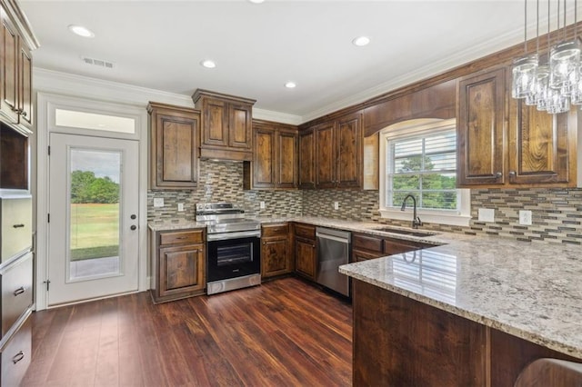 kitchen with pendant lighting, stainless steel appliances, sink, light stone counters, and crown molding