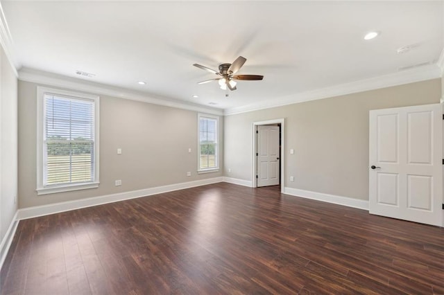 empty room with a wealth of natural light, dark hardwood / wood-style floors, and ornamental molding