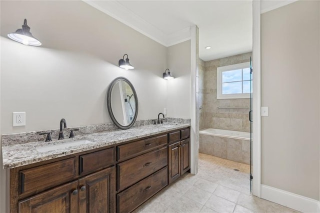 bathroom featuring tiled bath, vanity, crown molding, and tile patterned flooring