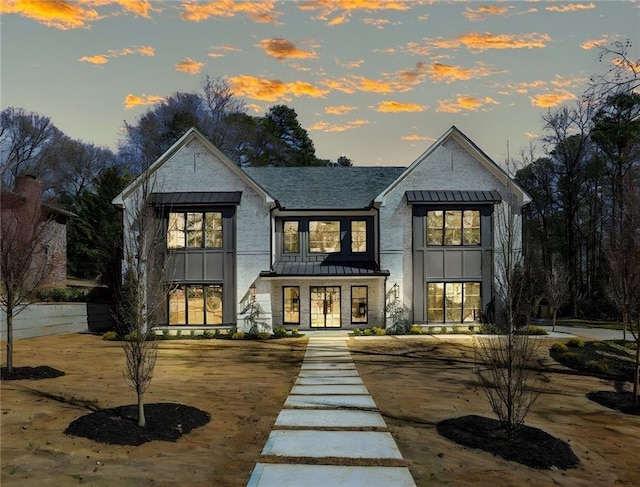 back of property featuring a standing seam roof, roof with shingles, and french doors