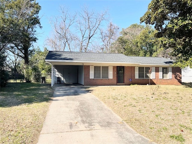 ranch-style house with brick siding, a front yard, fence, a carport, and driveway