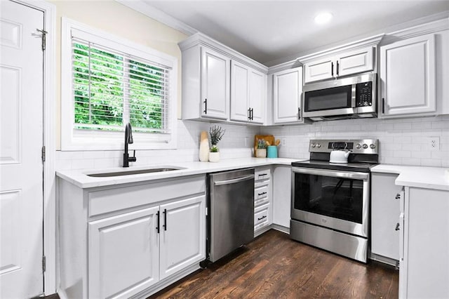 kitchen with sink, dark wood-type flooring, decorative backsplash, white cabinets, and appliances with stainless steel finishes