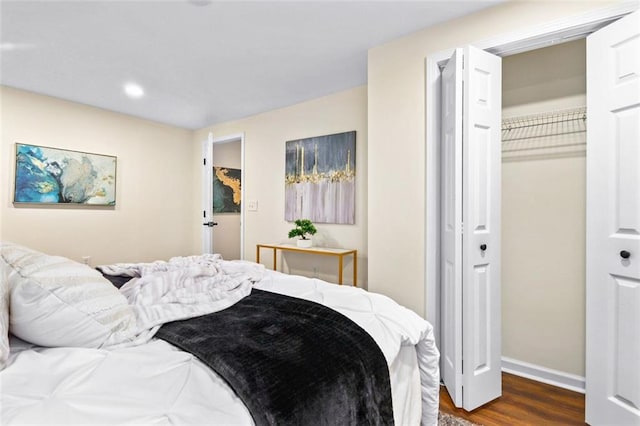 bedroom with dark hardwood / wood-style flooring and a closet