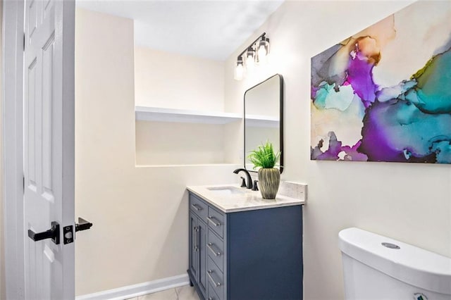 bathroom with tile patterned flooring, vanity, and toilet