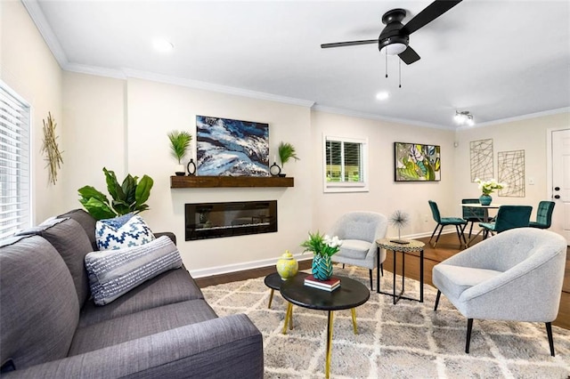 living room with wood-type flooring, plenty of natural light, ceiling fan, and crown molding