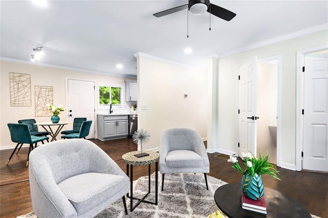 sitting room with dark wood-type flooring, ceiling fan, and ornamental molding