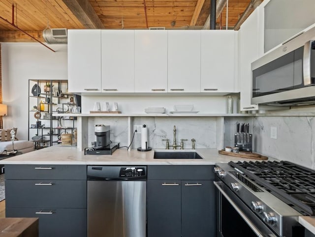 kitchen with tasteful backsplash, wood ceiling, gray cabinets, appliances with stainless steel finishes, and a sink