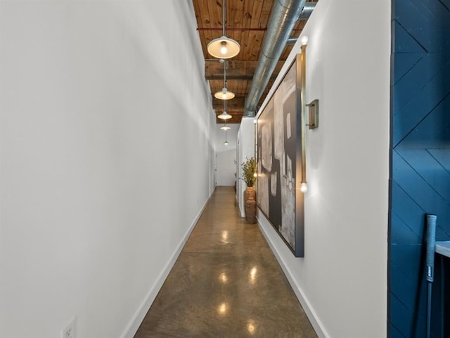 corridor featuring baseboards and finished concrete floors