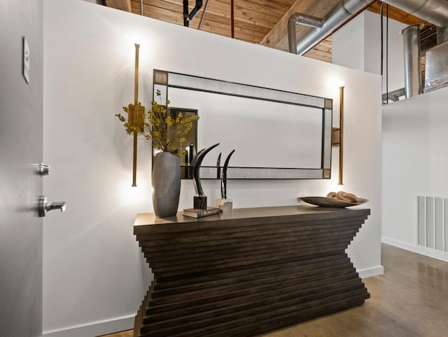 interior details featuring visible vents, baseboards, bar, and concrete flooring