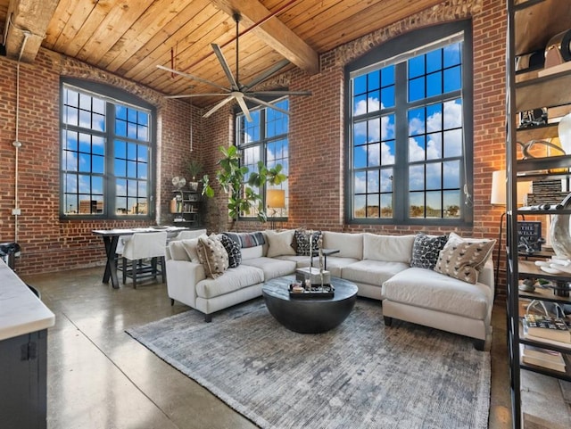 living room featuring wooden ceiling, brick wall, concrete floors, and a towering ceiling