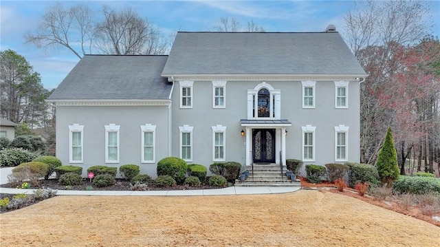 view of front facade with a front lawn and stucco siding