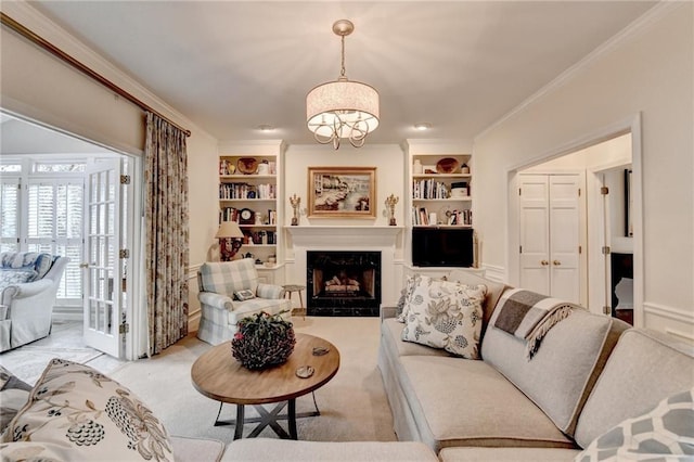 living room with ornamental molding, a premium fireplace, carpet, and built in shelves