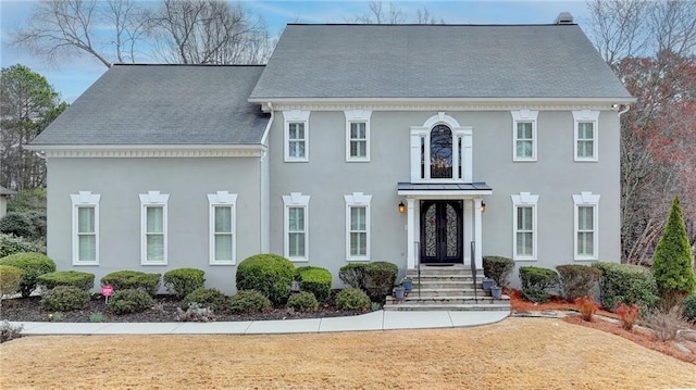 view of front of house featuring stucco siding, french doors, and a shingled roof