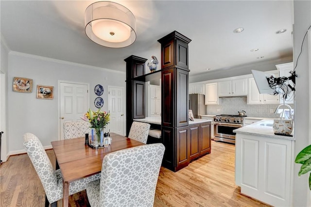 dining area with baseboards, recessed lighting, light wood-style flooring, and crown molding