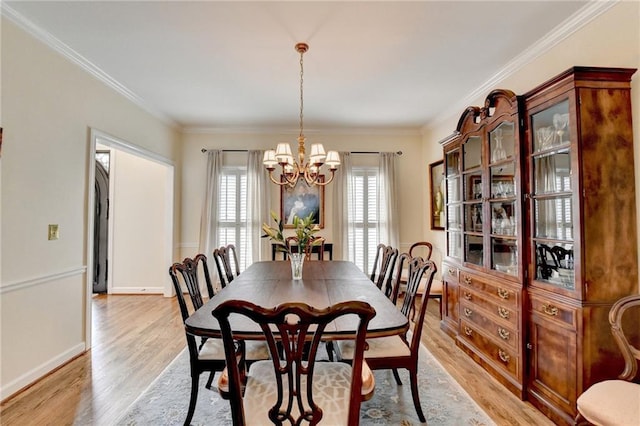 dining space with light wood finished floors, baseboards, a chandelier, and ornamental molding