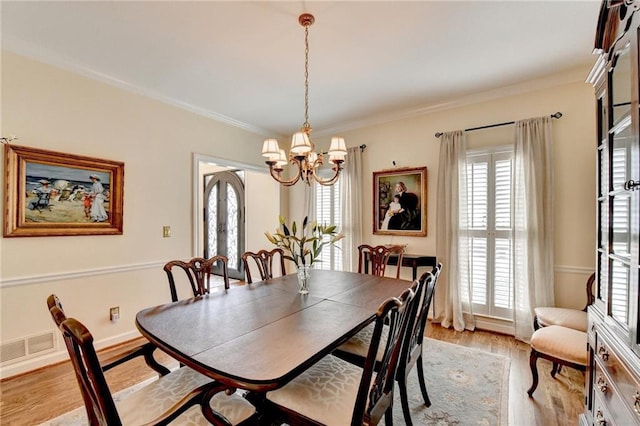 dining room with light wood-style floors, a wealth of natural light, and ornamental molding