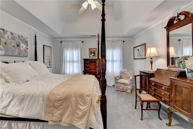 carpeted bedroom with ornamental molding, a tray ceiling, visible vents, and a ceiling fan