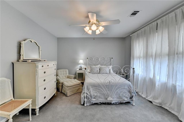 carpeted bedroom featuring a ceiling fan and visible vents