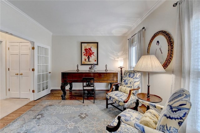 living area with baseboards, wood finished floors, and crown molding