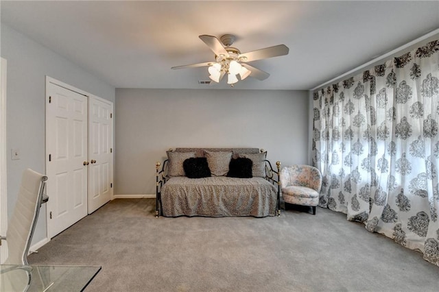 carpeted bedroom featuring ceiling fan, visible vents, and a closet