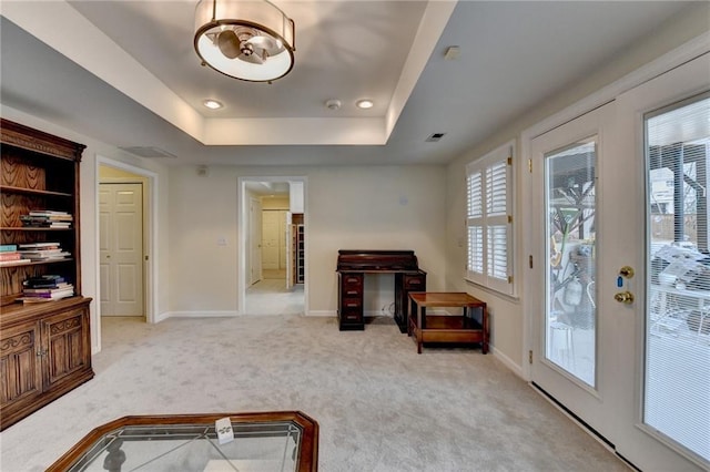 sitting room with carpet, a raised ceiling, visible vents, and baseboards