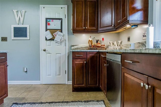 kitchen featuring stainless steel dishwasher, light tile patterned flooring, baseboards, and dark brown cabinetry