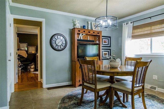 dining area featuring a chandelier, crown molding, tile patterned floors, baseboards, and a textured ceiling