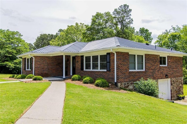 single story home with a front lawn, a garage, metal roof, and brick siding