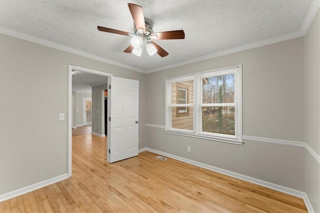 unfurnished room with a textured ceiling, ceiling fan, light wood-type flooring, and crown molding