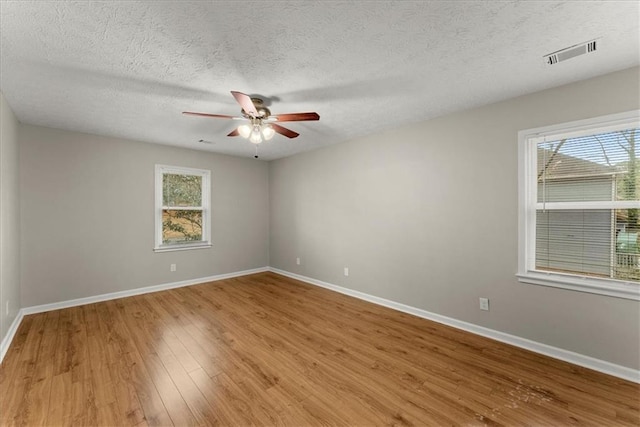 unfurnished room with wood-type flooring and a textured ceiling