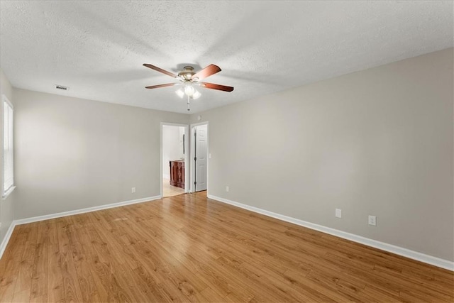 unfurnished room featuring ceiling fan, light hardwood / wood-style flooring, and a textured ceiling