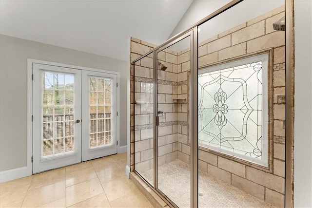 entryway with french doors, light tile patterned floors, and vaulted ceiling