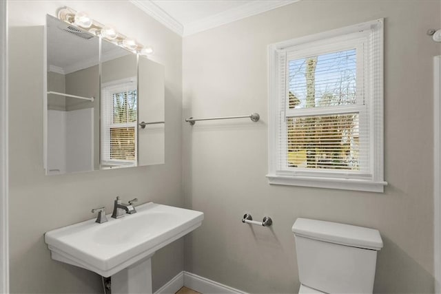 bathroom with toilet, plenty of natural light, and sink