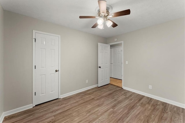 unfurnished bedroom with ceiling fan and light hardwood / wood-style flooring