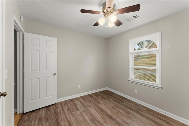 empty room featuring wood-type flooring and ceiling fan