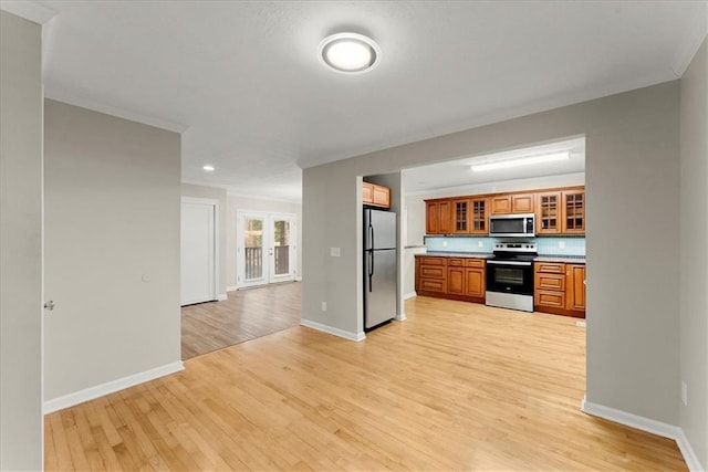 kitchen featuring tasteful backsplash, french doors, light hardwood / wood-style floors, and appliances with stainless steel finishes