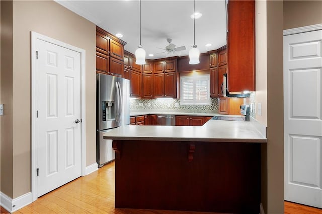 kitchen with kitchen peninsula, appliances with stainless steel finishes, ceiling fan, and pendant lighting