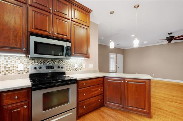 kitchen with ceiling fan, kitchen peninsula, pendant lighting, appliances with stainless steel finishes, and light wood-type flooring