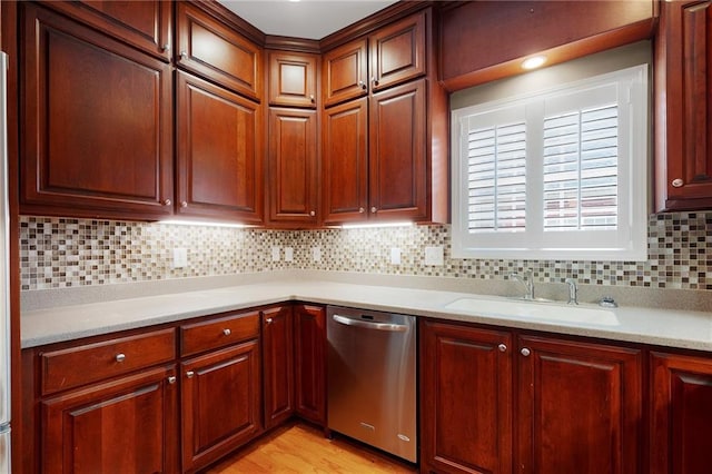 kitchen featuring dishwasher, light wood-type flooring, tasteful backsplash, and sink