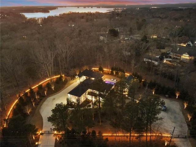 aerial view at dusk featuring a water view