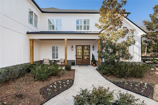 view of exterior entry with covered porch and french doors