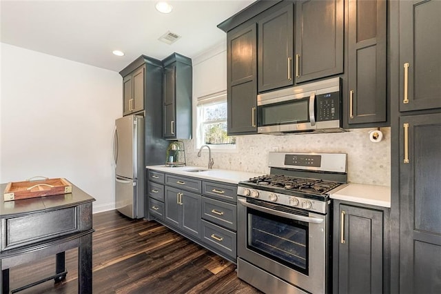 kitchen featuring appliances with stainless steel finishes, gray cabinets, sink, and decorative backsplash