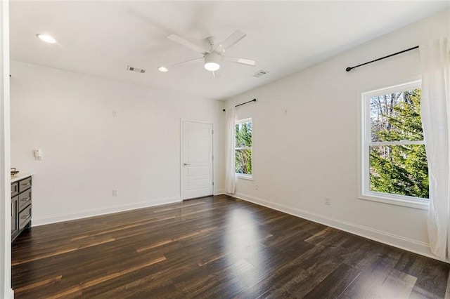 unfurnished room with dark hardwood / wood-style flooring and ceiling fan