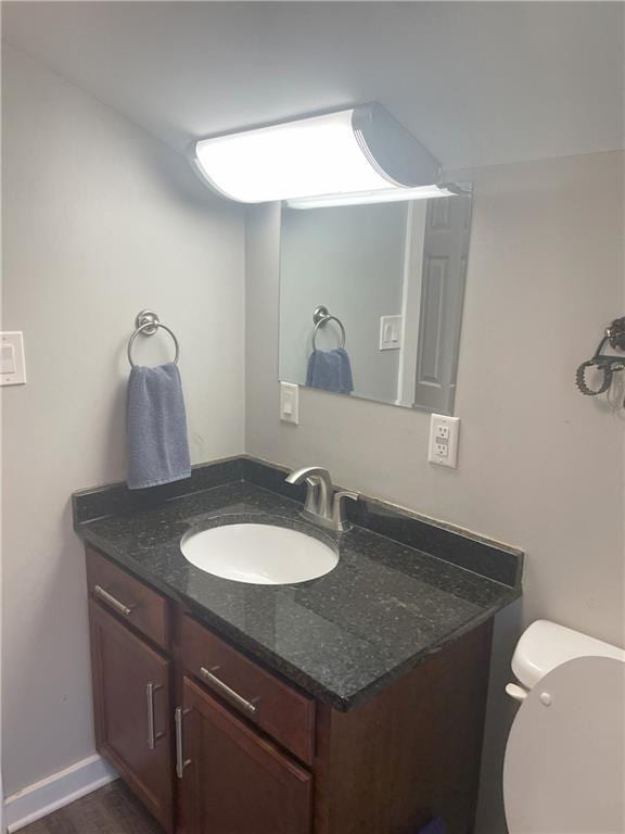 half bath featuring toilet and vanity