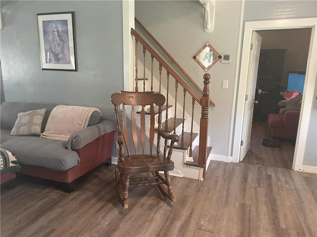 living room with wood finished floors, baseboards, and stairs