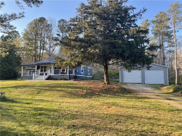view of front facade featuring covered porch, a detached garage, an outdoor structure, a front yard, and driveway