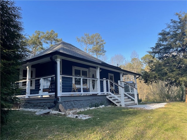 exterior space featuring a porch, a shingled roof, and a front lawn