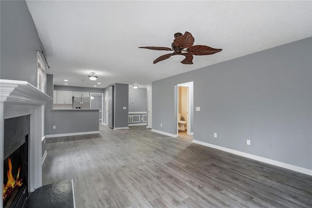 unfurnished living room with ceiling fan and dark hardwood / wood-style flooring