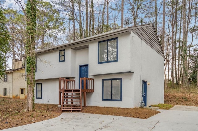 view of front of property featuring a chimney and stucco siding